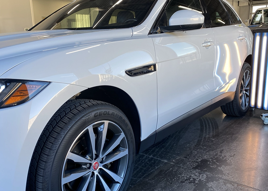 White Jaguar SUV undergoing paintless dent repair at Precision PDR